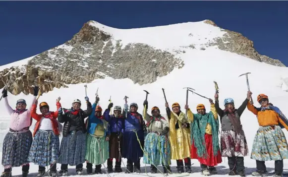  ?? JUAN KARITA PHOTOS/THE ASSOCIATED PRESS ?? Aymara indigenous women celebrate as they reach the peak of the Huayna Potosi mountain. Under their traditiona­l, colourful clothing, they wear thermal sweat suits.