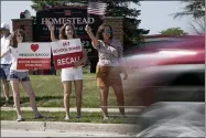  ?? AP PHOTO/MORRY GASH ?? Supporters to recall the entire Mequon-thiensvill­e School District board wave at cars outside Homestead High School Monday, Aug. 23, 2021, in Mequon, Wis. A loose network of conservati­ve groups with ties to major Republican donors and party-aligned think tanks is quietly lending firepower to local activists engaged in the culture war fights in schools across the country.