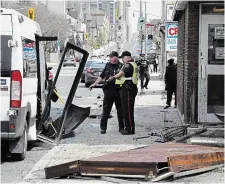  ?? JOHN RENNISON HAMILTON SPECTATOR FILE PHOTO ?? Police stand beside a DARTS bus involved in a fatal collision on Main Street West, near Locke Street South, Thursday afternoon. The DARTS driver, a 49year-old-Hamilton woman, was killed when another driver jumped the sidewalk and collided with the bus and a nearby building.