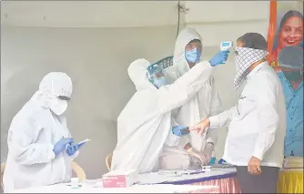  ??  ?? Health workers check the temperatur­e and oxygen level of a resident at Malad on Monday.