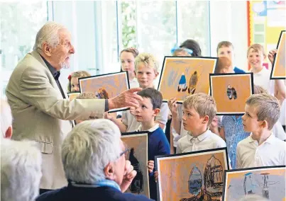  ?? Picture: Dougie Nicholson. ?? Artist James Morrison casts an eye over pupils’ versions of his painting Catterline Boats at Catterline Primary School.