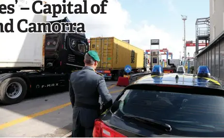  ?? — AFP file photos ?? An officer of the Guardia di Finanza, the Italian police in charge of financial crime and smuggling, checks trucks transporti­ng containers in the commercial area of the port of Naples.