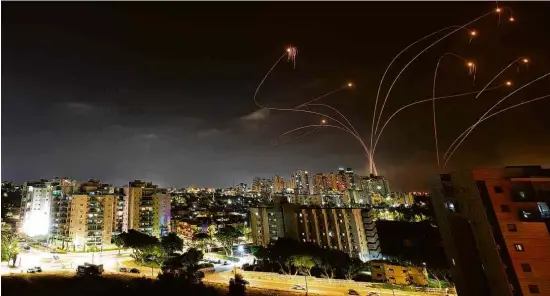  ?? Amir Cohen/Reuters ?? Mísseis do sistema israelense de defesa aérea Domo de Ferro intercepta­m foguetes disparados da Faixa de Gaza sobre a cidade de Ashkelon