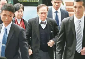  ??  ?? 香港前特首曾蔭權(中)20日在妻子曾鮑笑薇(左二)陪同下抵達香港高等法­院聆訊，他被控一項「公職人員行為不當罪」成立。 (美聯社)