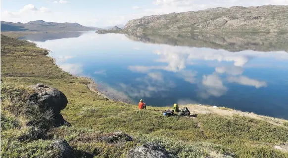  ?? PHOTOS: DINA MISHEV/FOR THE WASHINGTON POST ?? Greenland’s 6.5-kilometre-long Lake Amitsorsua­q is a scenic spot along the Arctic Circle Trail, a perfect place to drop that hiking gear and admire the stunning view. Top: Sisimiut, the second largest community in Greenland, combats gloomy maritime weather with brightly coloured homes and buildings.