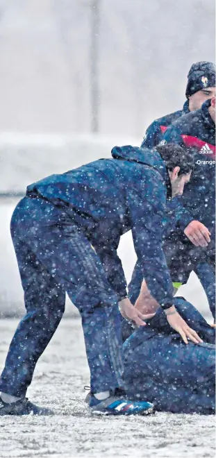  ??  ?? Cold snap: France knuckle down in the snow at training near Paris yesterday