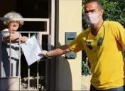  ??  ?? Un agent municipal remet un sachet contenant masque et instructio­ns à une Cannettane. (Photo I. V.)