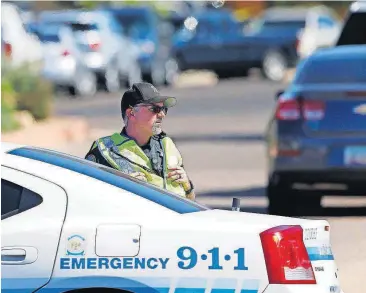  ?? [AP PHOTO] ?? A Scottsdale Police Department officer blocks off traffic Monday in Scottsdale, Ariz., as police surround a local hotel where a suspect wanted in several killings was staying. According to police, the suspect killed himself as police closed in on the...