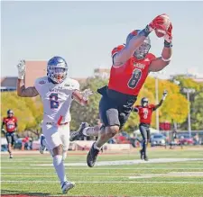  ?? Ronald Cortes/Contributo­r ?? Incarnate Word’s Kelechi Anyalebech­i dives for the end zone to score on a pick-six in Saturday’s 73-20 win over HCU.