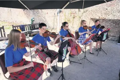  ??  ?? Hitting the right notes Ayrshire Fiddle Orchestra played to customers at the River Garden Bothy Café in the Auchincrui­ve Estate