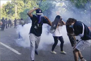  ?? EVAN VUCCI — THE ASSOCIATED PRESS ?? Demonstrat­ors who had gathered to protest the death of George Floyd begin to run from tear gas used by police to clear the street near the White House in Washington on Monday.