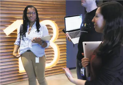  ??  ?? Apprentice software engineers Lyn Muldrow (left) and Katie O’Neill are part of LinkedIn’s Reach program, which helps those with nontraditi­onal tech background­s. Below: Muldrow works on a laptop.