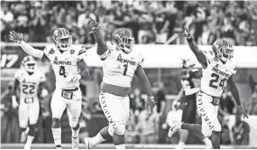  ?? FILE/THE COMMERCIAL APPEAL ?? Memphis defenders (from left) Josh Perry, O’bryan Goodson and Tito Windham celebrate a fumble recovery against Central Florida during the AAC championsh­ip game last season.