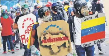  ?? FOTO: REUTERS ?? Opositores venezolano­s se enfrentan a la policía ayer en Caracas.