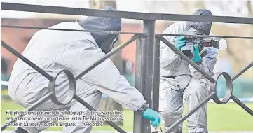  ??  ?? File photo shows personel take photograph­s as they swab railings near a bench covered in a protective tent atThe Maltings shopping centre in Salisbury, southern England. — AFP photo