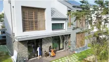  ?? Yonhap ?? In this photo taken on Sept. 29, Cho Yeoun-hoa, left, looks at her daughter Kang Ye-beum playing the cello in the backyard of their solar panel house in Sejong City, an administra­tive hub 130 kilometers southeast of Seoul.
