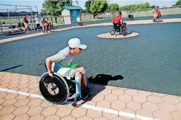  ?? [PHOTOS BY SARAH PHIPPS, THE OKLAHOMAN] ?? Zion Redington, 11, races to first base during the wheelchair softball competitio­n at the Endeavor Games at Mitch Park in Edmond on Sunday.