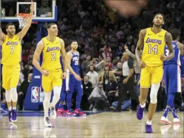  ?? CHRIS SZAGOLA — THE ASSOCIATED PRESS ?? Lakers forward Brandon Ingram, right, reacts to hitting the winning basket along with Lonzo Ball, center, and Larry Nance Jr., left, against the Sixers on Thursday.