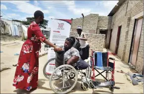  ?? ?? Chipo Mahamba hands over a wheelchair to one of Vana Vedu Trust beneficiar­ies