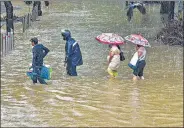  ?? PTI ?? People wade through a waterlogge­d street after heavy rain at Parel area in Mumbai on Wednesday.
