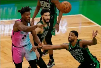  ?? AP Photo/Steven Senne ?? Miami Heat’s Gabe Vincent (left) passes the ball as Boston Celtics’ Jayson Tatum, center, and Tristan Thompson, right, try to block in the first half of a basketball game, on Sunday in Boston.