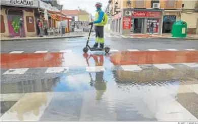  ?? ÁLVARO CABRERA ?? Un hombre en patinete, bajo la lluvia ayer en Málaga capital.