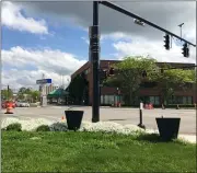  ?? RICHARD PAYERCHIN — THE MORNING JOURNAL ?? Three planters await new flowers at the intersecti­on of Broadway and West Erie Avenue in Lorain. On May 30, the Main Street Lorain Design Committee, the Lorain Section of the National Council of Negro Women and the city of Lorain will bring six large self-watering flower containers, similar to those shown, and 60, 12-inch flower pots to line Broadway.