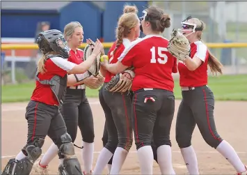  ?? ?? The Lady Big Red celebrate after the final out of their eight-inning 8-6 District semifinal victory over Monroevill­e Tuesday night at Galion’s Heise Park. Plymouth rallied with three runs in the seventh and two in the eighth. Photo by Dan Woodlock