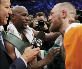  ?? ISAAC BREKKEN — THE ASSOCIATED PRESS ?? Floyd Mayweather Jr., left, speaks with Conor McGregor after a super welterweig­ht boxing match Saturday in Las Vegas.