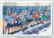  ??  ?? Students in Cairns cheering a baton bearer.