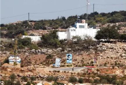  ?? (Ammar Awad/Reuters) ?? A BANNER depicting Hezbollah leader Hassan Nasrallah and an United Nation’s post are seen in Lebanon this week from the Israeli side of the border.