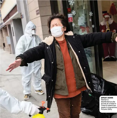  ??  ?? SPRAY DOWN Woman is disinfecte­d as she arrives at a hotel in China to spend two weeks in quarantine. Picture: Getty