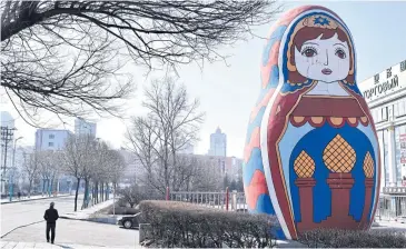  ?? PHOTOS REUTERS ?? ABOVE
A man walks past a giant statue of Russia’s famous nesting dolls in Suifenhe, Heilongjia­ng province, China, on the border with Russia.