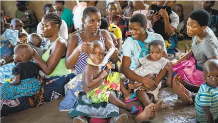  ?? JEROME DELAY AP ?? Residents of Malawi wait to have their children become test subjects for the world’s first vaccine against malaria in 2019. The World Health Organizati­on recommende­d the vaccine Wednesday, a move that officials hope will help curb the spread of the disease.