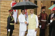  ?? ERANGA JAYAWARDEN­A / AP ?? Indian Prime Minister Narendra Modi is received by the Sri Lankan President Maithripal­a Sirisena (holding umbrella) upon his arrival Sunday at the presidenti­al secretaria­t in Colombo, Sri Lanka.
