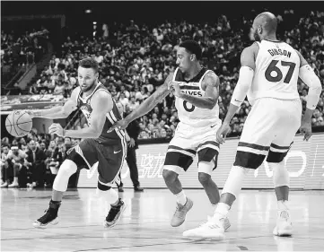  ?? — AFP photo ?? Golden State Warriors’ Stephen Curry (left) controls the ball during the NBA game against Minnesota Timberwolv­es in Shanghai in this Oct 8 file photo.