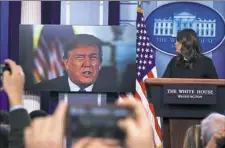  ?? Manuel Balce Ceneta/Associated Press ?? President Donald Trump speaks via a video monitor to journalist­s Thursday in the White House during a press briefing with press secretary Sarah Huckabee Sanders.