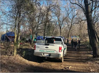  ?? MICHAEL WEBER — ENTERPRISE-RECORD ?? Chico Police Target Team officers and Park Rangers standby as Butte Countywide Continuum of Care volunteers administer the 2023Point in Time Count surveys Wednesday at Teichert Ponds in Chico.