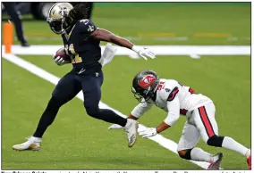  ?? (AP/Brett Duke) ?? New Orleans Saints running back Alvin Kamara (left) scores as Tampa Bay Buccaneers safety Antoine Winfield Jr. defends in the first half Sunday in New Orleans.
