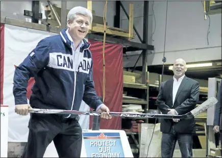  ?? RYAN REMIORZ/CANADIAN PRESS ?? Conservati­ve Leader Stephen Harper jokes with photograph­ers during a campaign stop at a company that makes hockey rink boards in Port Moody, B.C., Tuesday. Cascadia Sports Systems owner Murdo Paterson, right, looks on.