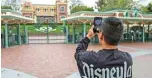  ??  ?? In this file photo taken on March 14, 2020 a man takes a photo outside the gates of Disneyland Park on the first day of the closure of Disneyland and Disney California Adventure theme parks.—AFP