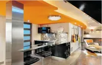  ??  ?? The design-build team of Suzanne and Mike Martin turned a dark and dingy basement into a light, airy space that’s welcoming and fun with pops of orange and curving bulkheads.