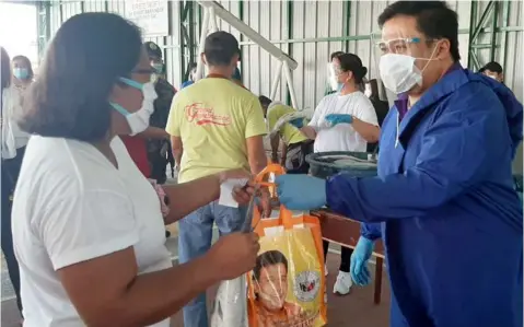  ?? (Princess Clea Arcellaz) ?? AID TO KABALENS. Former Senator Jinggoy Estrada hands over a whole bangus and a bag of relief goods to a Tomasian during his visit to Sto. Tomas town on Thursday.