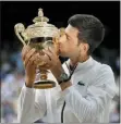  ?? TIM IRELAND — THE ASSOCIATED PRESS ?? Novak Djokovic kisses the trophy after defeating Roger Federer in the men’s singles final at Wimbledon Sunday.