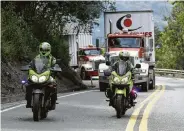  ?? Fernando Vergara / Associated Press ?? Two trucks containing humanitari­an aid from the U.S. for Venezuela are escorted by Colombia police. But will the supplies be allowed to cross the border?