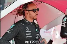  ?? HAMAD MOHAMMED, POOL/AP PHOTO ?? Mercedes driver Lewis Hamilton of Britain holds an umbrella prior to the start of the Azerbaijan Formula One Grand Prix at the Baku circuit, in Baku, Azerbaijan on June 12.