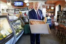  ?? Evan Vucci/Associated Press ?? President Donald Trump holds a pizza during a visit to Arcaro and Genell restaurant Thursday after speaking at a campaign event in Old Forge, Pa.