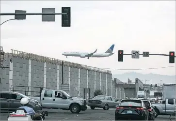  ?? Brian van der Brug Los Angeles Times ?? SOME RESIDENTS believe investment in the area has been a long time coming and may benefit newcomers rather than long-timers. Above, a plane f lies over constructi­on of the Crenshaw/LAX light-rail line last year.