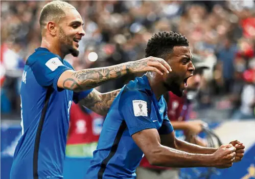  ?? — Reuters/ AFP ?? No sweat: France’s Thomas Lemar (right) is congratula­ted by Layvin Kurzawa after scoring against Holland in a World Cup European Zone Group A qualifying match on Thursday. France won 4- 0. Below: Cristiano Ronaldo scoring with an acrobatic volley...