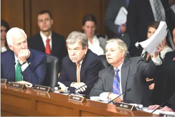  ??  ?? Senator Graham, holds up terms of use for Facebook as the company’s CEO, Zuckerberg, appears for a hearing last Tuesday in Washington, D.C.